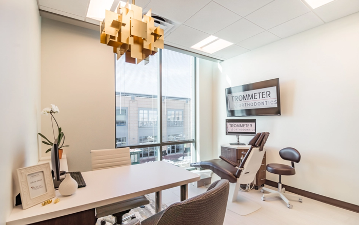 Trommeter Orthodontics | Private consultation room at Trommeter Orthodontics with a desk, dental chair, and large window view.